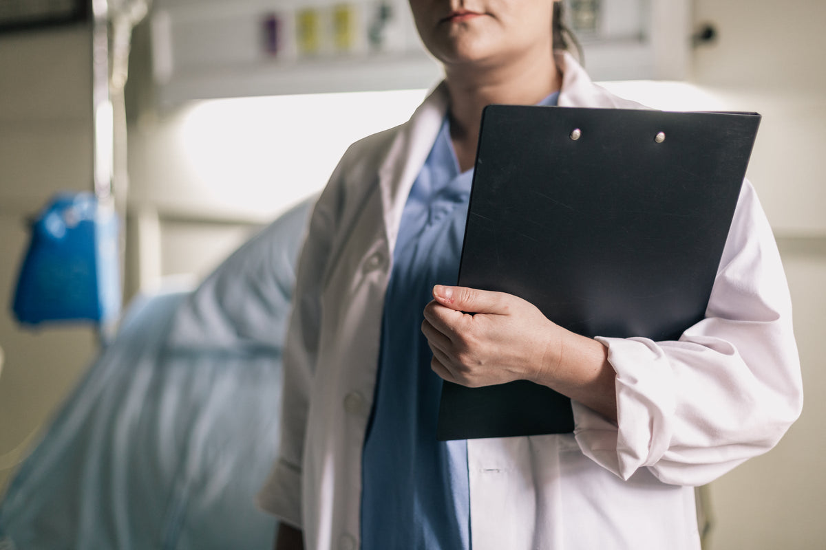 Nurse holding a clipboard in a hospital room
